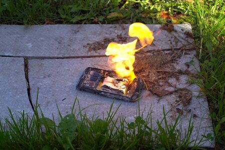 Burning smartphone, burning mobile phone. Flammable telephoneの写真素材