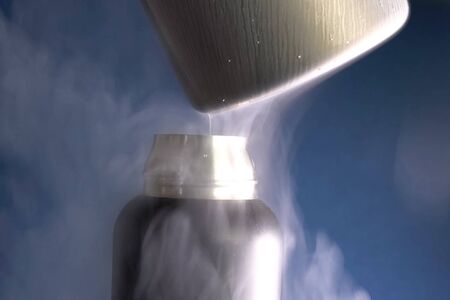 Liquid air, pouring liquefied air into a thermos.の写真素材