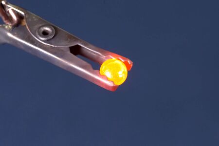 Warmed to red bearing in steel nippers.の写真素材