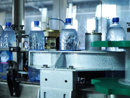 Filling line of sparkling water in a pet bottle. Mini factory for bottling water.の写真素材