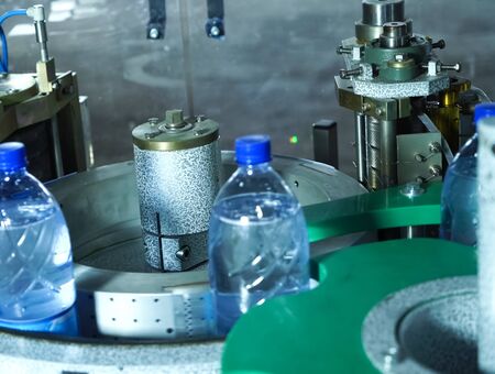 Filling line of sparkling water in a pet bottle. Mini factory for bottling water.の写真素材