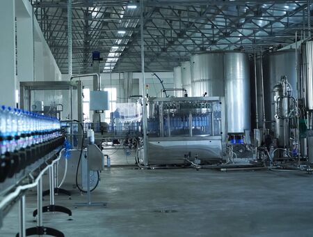 Filling line of sparkling water in a pet bottle. Mini factory for bottling water.の写真素材
