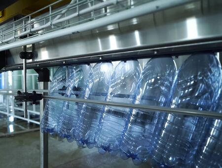 Filling line of sparkling water in a pet bottle. Mini factory for bottling water.