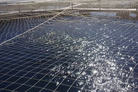 Fish farm on the lake, covered with a net.の写真素材
