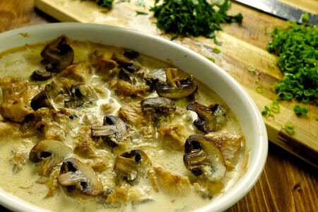 Fried chicken with mushrooms, milk and green onions.の写真素材