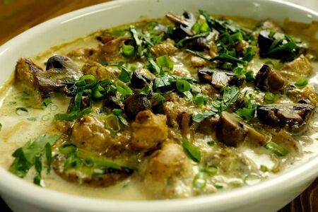 Fried chicken with mushrooms, milk and green onions.の写真素材