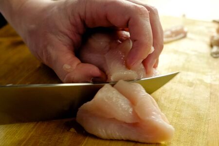 Cutting poultry meat. Broiler breast, chicken meat on a cutting board.の写真素材