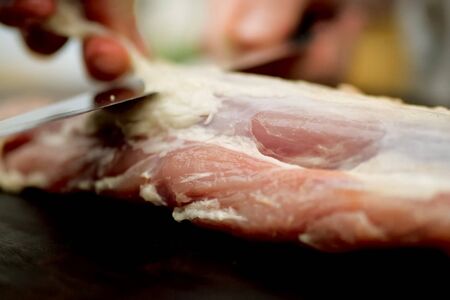 Cutting a piece of pork meat on the table. Raw pork.の写真素材