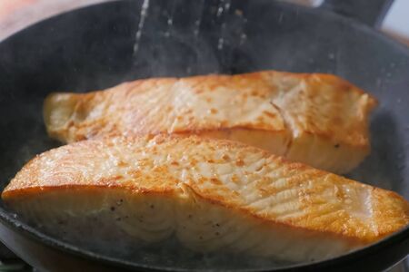 Frying red fish in a pan. Pieces of red fish.の写真素材