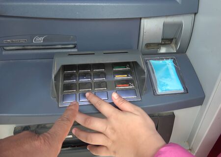 ATM for receiving funds. Hands of a man at an ATM. Withdraw money from an ATM.の写真素材