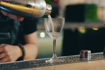 a Bartender pouring cocktail at bar counter
