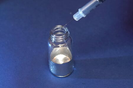 Liquid metal in a flask. Take liquid metal with a syringe.の写真素材
