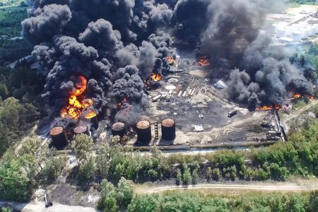 Oil storage fire. The tank farm is burning, black smoke is the combustion of hydrocarbons.の写真素材