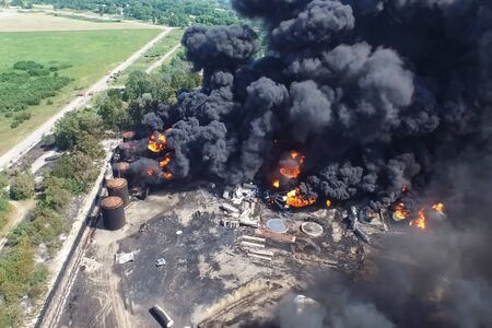 Oil storage fire. The tank farm is burning, black smoke is the combustion of hydrocarbons.の写真素材