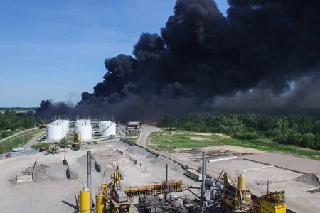 Oil storage fire. The tank farm is burning, black smoke is the combustion of hydrocarbons.の写真素材