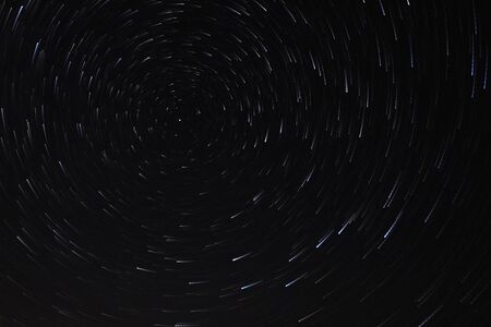 Long exposure starry sky, twisted tracks of stars. Starry sky background picture of stars in the night sky and the Milky Way.の写真素材