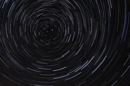 Long exposure starry sky, twisted tracks of stars. Starry sky background picture of stars in the night sky and the Milky Way.の写真素材