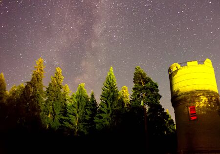 Starry sky background picture of stars in the night sky and the Milky Way. Starry sky over the forest and the water tower.の写真素材