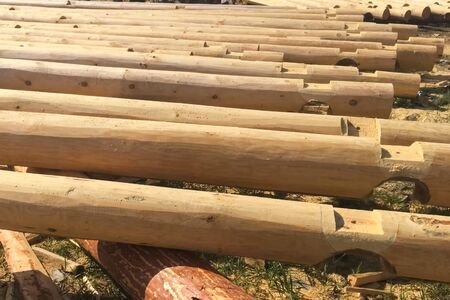 Drying and assembly of a wooden log house at a construction base. Preparation of logs for the...