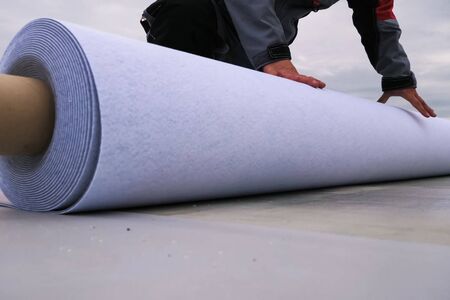 Rolls of polymer coating for the roof. Deployment of a roof covering roll.の写真素材