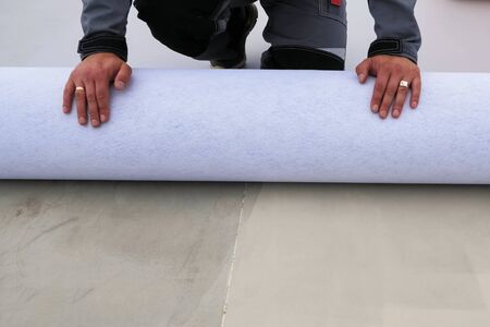 Rolls of polymer coating for the roof. Deployment of a roof covering roll.の写真素材