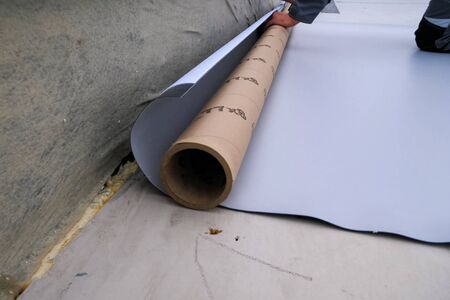Rolls of polymer coating for the roof. Deployment of a roof covering roll.の写真素材