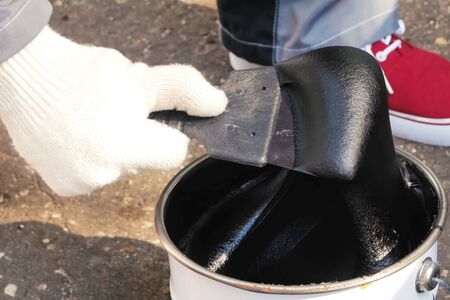 Bituminous mastic on a spatula. building mixtures and coatings.の写真素材