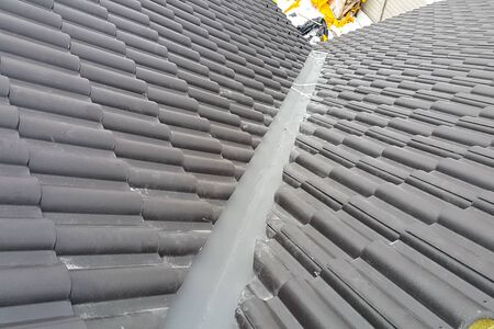 Modern roof made. Installation of the roof of the house from ceramic black tiles. Installation of tiles on the roof.の写真素材