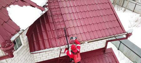 Moscow, Russia - February 15, 2019: Worker does the installation of the roof of the house....