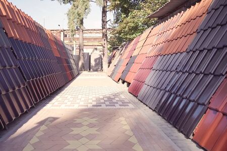 Samples of ceramic roofing tiles in a warehouse of a roofing materials store. Modern roof made of metal. cement sand tiles.の写真素材