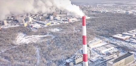 smoking chimney of a thermal power plant on the background of a winter city.の写真素材