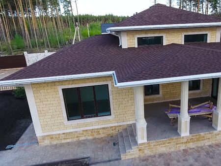 House with a roof from a bituminous tile. Bituminous tile for a roof. a roof from a bituminous tile.の写真素材