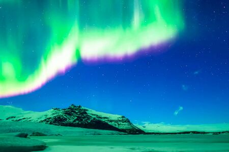 Aurora borealis in the night northern sky. Ionization of air particles in the upper atmosphere.の写真素材
