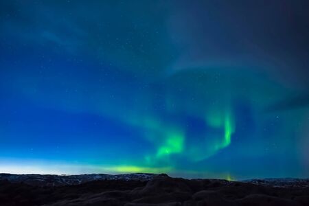 Aurora borealis in the night northern sky. Ionization of air particles in the upper atmosphere.の写真素材