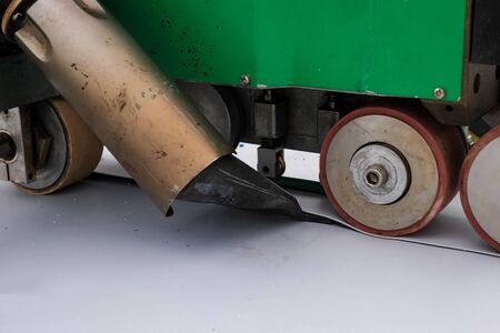 The mechanism for laying and gluing sheets of roofing polymer. Adhesion of polymer roofing sheets.の写真素材