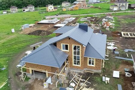 House with a new roof made of metal, Holiday village, view from above. Village in spring from above, houses and vegetable gardens.の写真素材