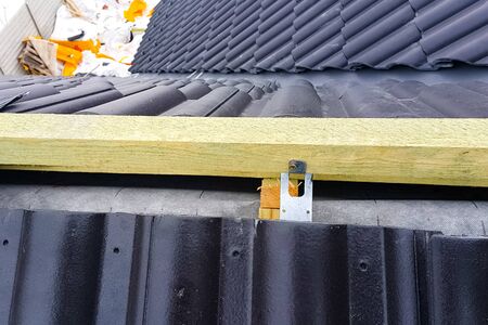 Modern roof made. Installation of the roof of the house from ceramic black tiles. Installation of tiles on the roof.の写真素材