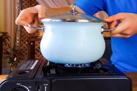 The cook puts the pan on the gas stove.の写真素材