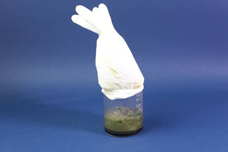Glove on measuring glass, a chemical reaction with the release of gas.の写真素材