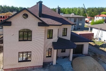 House with a roof from a bituminous tile. New brick house. Bituminous tile for a roof. a roof from a bituminous tile.の写真素材