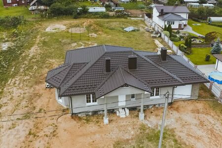 Modern roof made of metal. Corrugated metal roof and metal roofing. House with a brown metal roof.の写真素材