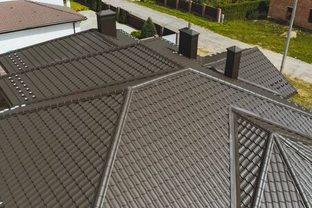 Modern roof made of metal. Corrugated metal roof and metal roofing. House with a brown metal roof.の写真素材