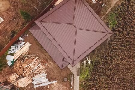 Modern roof made of metal. Corrugated metal roof and metal roofing. House with a brown metal roof.の写真素材