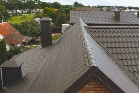 Modern roof made of metal. Corrugated metal roof and metal roofing. House with a brown metal roof.の写真素材