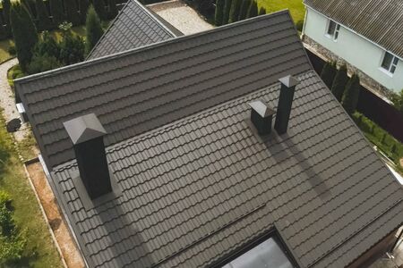 Modern roof made of metal. Corrugated metal roof and metal roofing. House with a brown metal roof.の写真素材