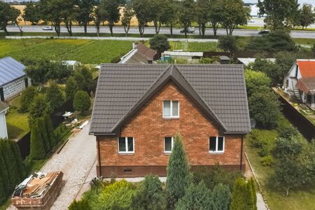 Modern roof made of metal. Corrugated metal roof and metal roofing. House with a brown metal roof.の写真素材