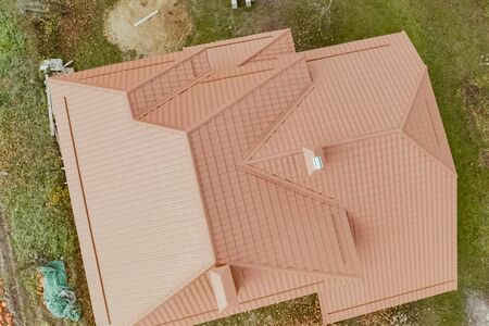 Modern roof made of metal. Corrugated metal roof and metal roofing. House with an orange metal roof.の写真素材