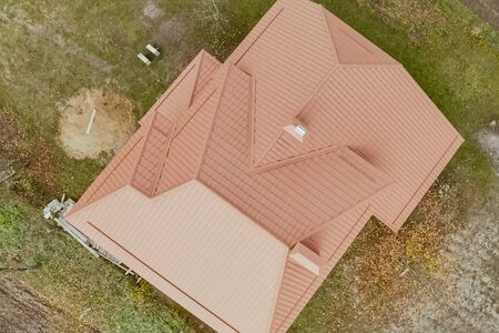 Modern roof made of metal. Corrugated metal roof and metal roofing. House with an orange metal roof.の写真素材