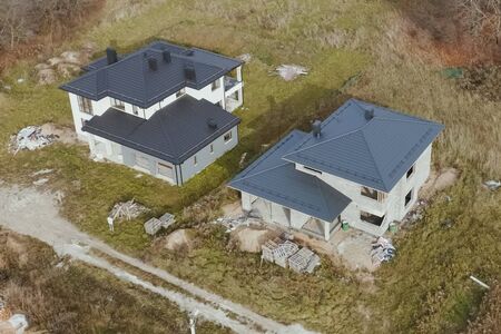 Modern roof made of metal. Corrugated metal roof and metal roofing. New houses under construction in the village. Houses with a roof made of metal.の写真素材