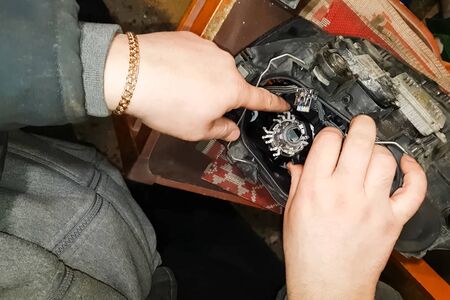 Xenon lamp in the hands of an electrician. Replacing xenon lamps.の写真素材